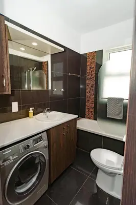 a bathroom with a washer and a toilet and a sink at Central 2 bdr Flat St Lazaros - Phoenix Lodge in Larnaka