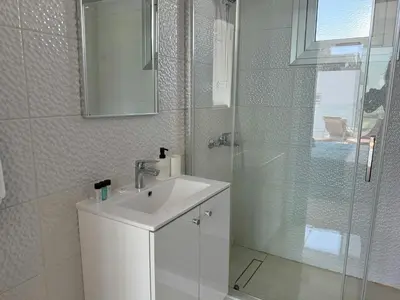 a white bathroom with a sink and a shower at TooCoool Villa - Elite Sea Breeze in Ayia Napa