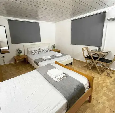 a room with two beds and a table and two screens at Comfortable Vacation House in Protaras