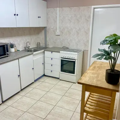 a kitchen with white cabinets and a sink and a stove at Comfortable Vacation House in Protaras