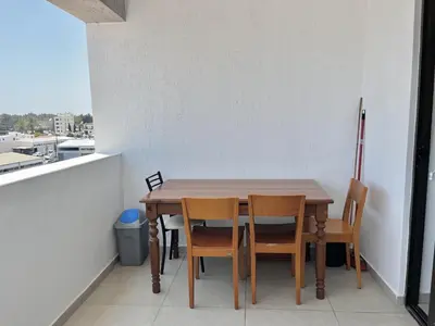 a table and chairs in a room with a balcony at STAY Sealine Apartment in Larnaka