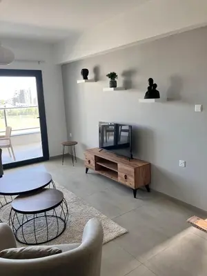 a living room with a tv and a table and chairs at Caesar Socrates Apartment in Larnaka