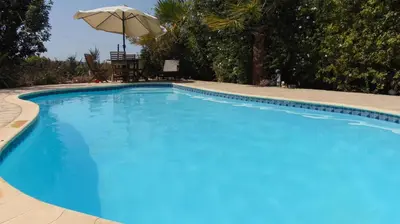 a large blue swimming pool with an umbrella at Konnos Villa in Protaras