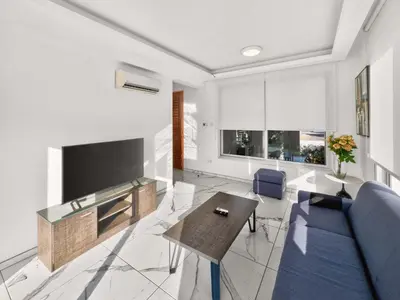 a living room with a tv and a blue couch at Alassia Blue Villa in Protaras