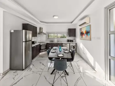 a kitchen with a table and chairs and a refrigerator at Alassia Blue Villa in Protaras