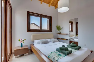 a bedroom with a bed with two green pillows at Amelia Beach Villa wpool -500mfrombeach in Voroklini