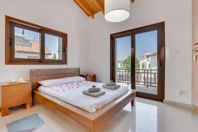 a bedroom with a bed and a large window at Amelia Beach Villa wpool -500mfrombeach in Voroklini