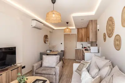 a living room with a couch and chairs and a kitchen at Pallini 202 in Protaras