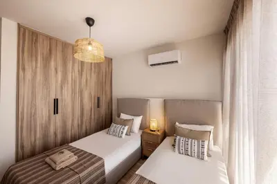 a bedroom with two beds and a chandelier at Pallini 202 in Protaras