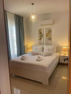 a bedroom with a white bed and a window at Lazuli Penthouse City Center Ap 5 in Larnaka