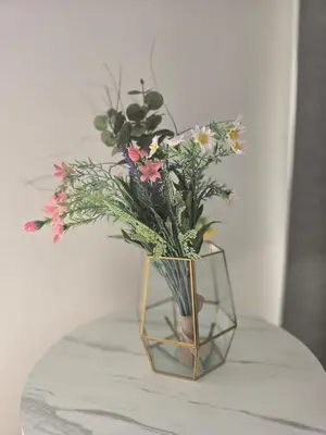 a glass vase with flowers in it on a table at Lazuli Penthouse City Center Ap 5 in Larnaka