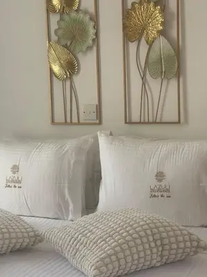 two mirrors above a bed with white pillows at Lazuli Penthouse City Center Ap 5 in Larnaka