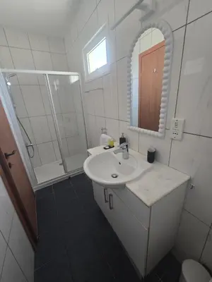 a white bathroom with a sink and a mirror at Lazuli Penthouse City Center Ap 5 in Larnaka