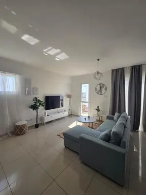 a living room with a blue couch and a tv at Lazuli Penthouse City Center Ap 5 in Larnaka