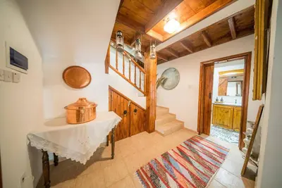 a hallway with a table and stairs in a house at Maison Des Vignes Lofou in Lofou