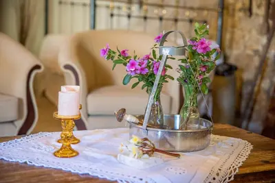 a table with flowers in vases on a table at Maison Des Vignes Lofou in Lofou