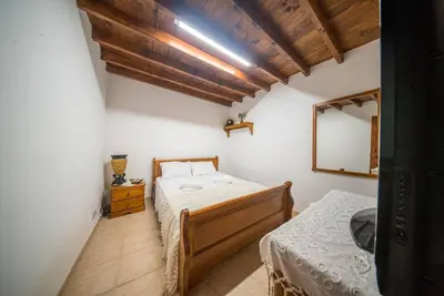 a bedroom with two beds and a mirror at Maison Des Vignes Lofou in Lofou