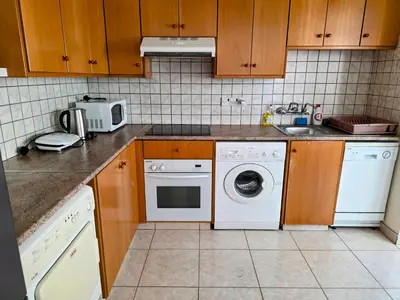 a kitchen with a washing machine and a sink at Niki's Coastal Escape in Larnaka