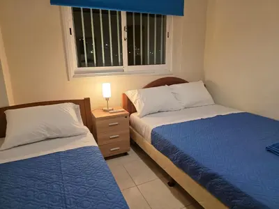 a bedroom with two beds and a window at Niki's Coastal Escape in Larnaka