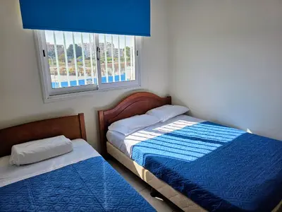two beds in a small room with a window at Niki's Coastal Escape in Larnaka