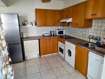 a kitchen with a refrigerator and a washer and dryer at Niki's Coastal Escape in Larnaka
