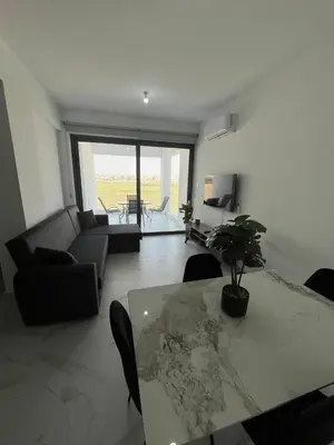 a living room with a table and a couch at Larnaca Elysium Seaside & Pool Retreat in Livadhia