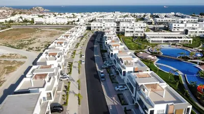 an aerial view of a city with white buildings and the ocean at Four seasons sitesi in Aglantzia