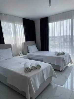 two beds in a hotel room with towels on them at Four seasons sitesi in Aglantzia