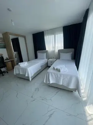 two beds in a room with marble floors and windows at Four seasons sitesi in Aglantzia