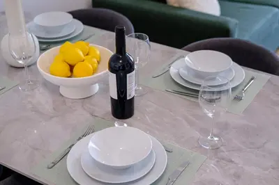 a table with a bottle of wine and a bowl of lemons at Artemis 204 - Seaside Stories in Livadhia