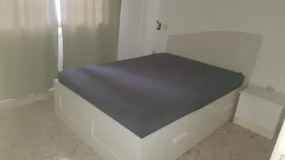 a bed in a white room with a black mattress at Nice Room in Limassol center in Limassol