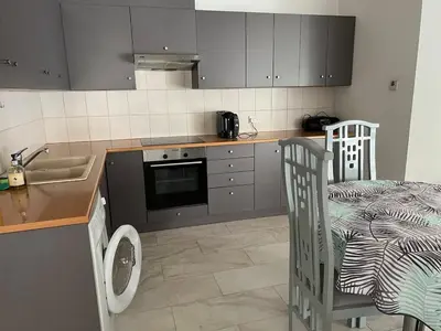 a kitchen with a sink and a counter with a table at Nice Room in Limassol center in Limassol