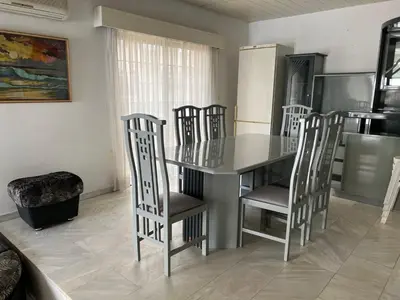 a dining room with a table and chairs and a kitchen at Nice Room in Limassol center in Limassol