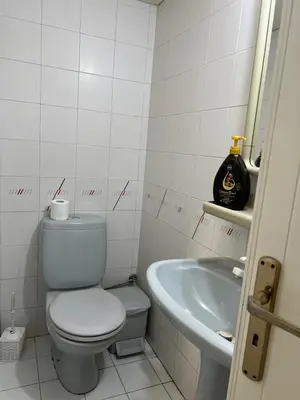 a white bathroom with a toilet and a sink at Nice Room in Limassol center in Limassol