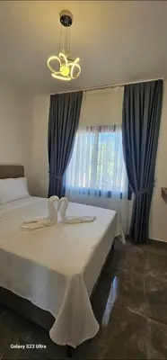 a bedroom with a large bed with blue curtains at Sunprime Premium Site in Pyla
