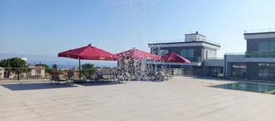 a fountain with red umbrellas in front of a building at Sunprime Premium Site in Pyla