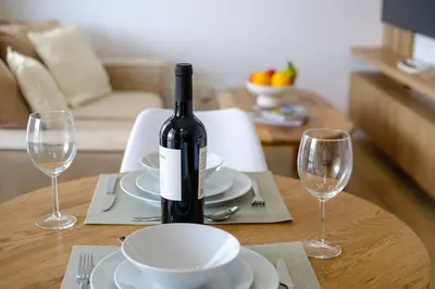 a bottle of wine sitting on a table with two glasses at Artemis 102 - Seaside Stories in Livadhia