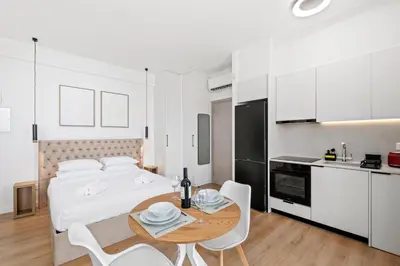 a bedroom with a bed and a table and chairs at Artemis 102 - Seaside Stories in Livadhia