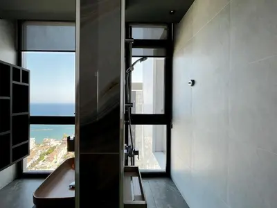 a bathroom with a shower with a view of the ocean at STAY ONLY Tower Suites in Limassol