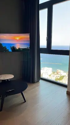 a living room with a table and a view of the ocean at STAY ONLY Tower Suites in Limassol