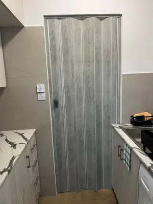 a bathroom with a sliding door in a kitchen at El Giorgios City Centre Apartment in Larnaka