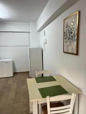 a dining room with a table and a refrigerator at El Giorgios City Centre Apartment in Larnaka