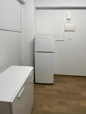 a white refrigerator in a kitchen with a wooden floor at El Giorgios City Centre Apartment in Larnaka