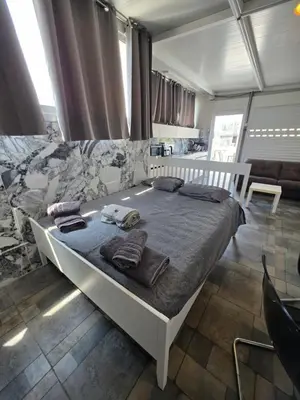 a bedroom with a large bed with towels on it at Costas Court in Limassol