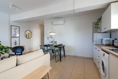 a living room and kitchen with a couch and a table at The Seven - One Bedroom Apartment in Paralimni