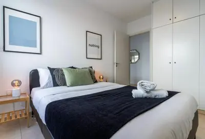 a bedroom with a large bed with a black blanket at The Seven - One Bedroom Apartment in Paralimni