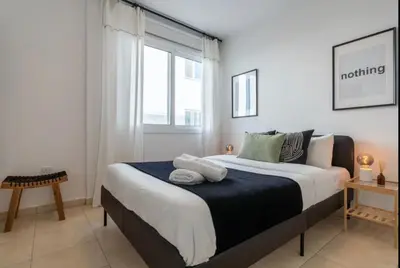 a bedroom with a large bed with a window at The Seven - One Bedroom Apartment in Paralimni