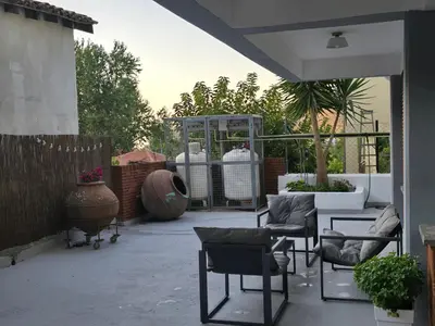 a patio with chairs and a table and a greenhouse at Maryland Lodge hideaway in Kakopetria