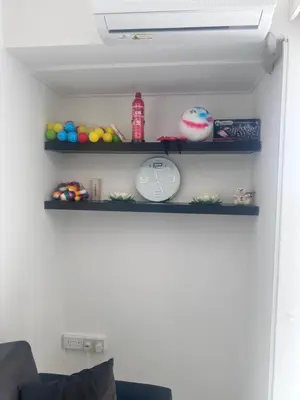a shelf with toys and a clock on a wall at Near Makenzie Beach 51 in Larnaka
