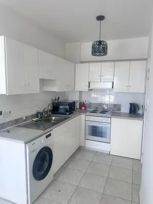 a white kitchen with a washing machine and a sink at Near Makenzie Beach 51 in Larnaka